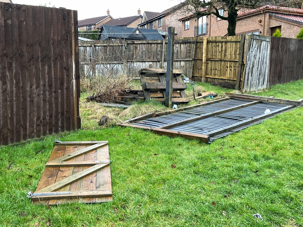 Broken wooden garden fence panels after storm damage