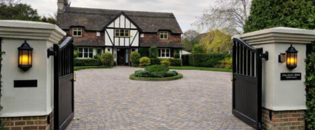 block paved driveway with electric gates showing where invisible dog fence cable can be installed across driveway entrance