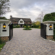block paved driveway with electric gates showing where invisible dog fence cable can be installed across driveway entrance