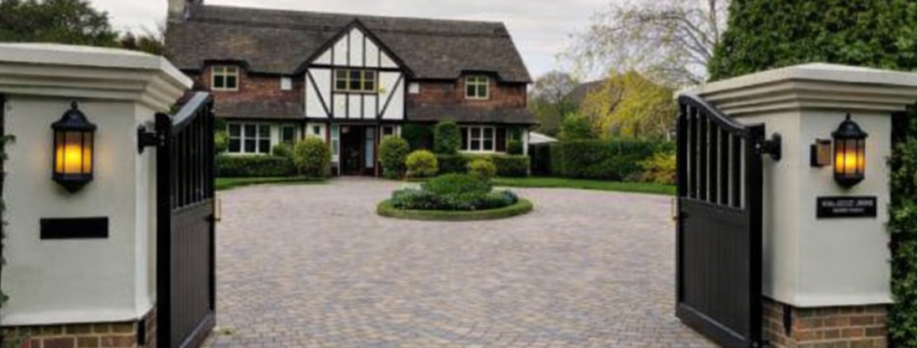 block paved driveway with electric gates showing where invisible dog fence cable can be installed across driveway entrance